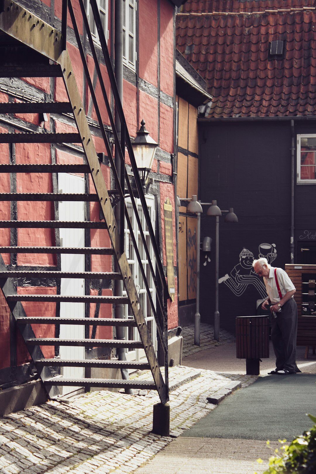 Photographer interviewing an elderly Danish man in his workshop